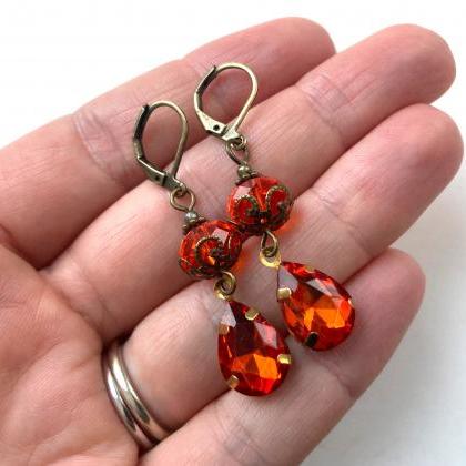 Shimmering earrings with orange gla..